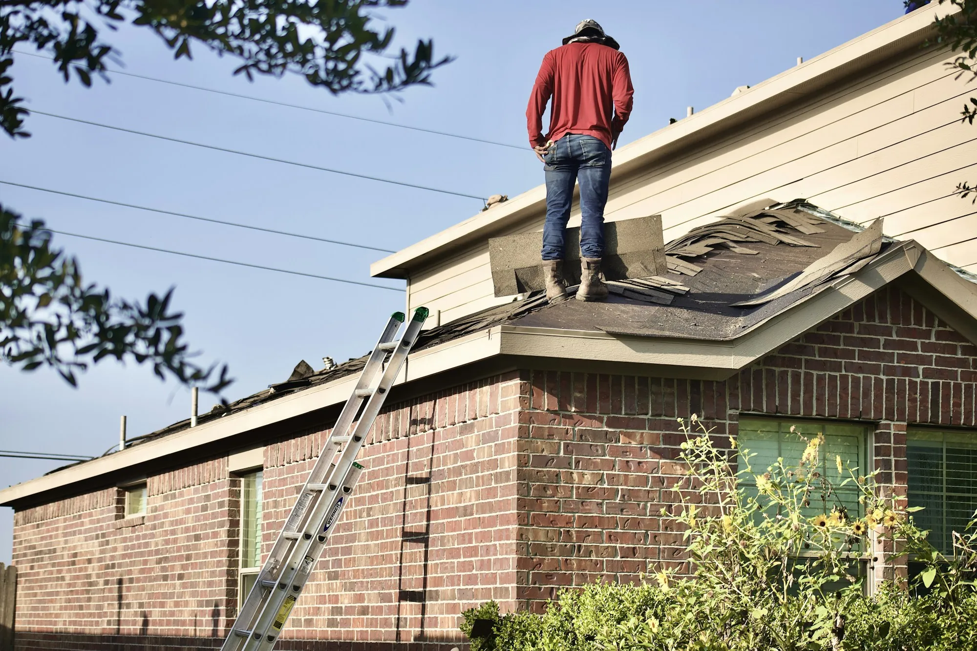 Roofer standing on a house roof at a work site