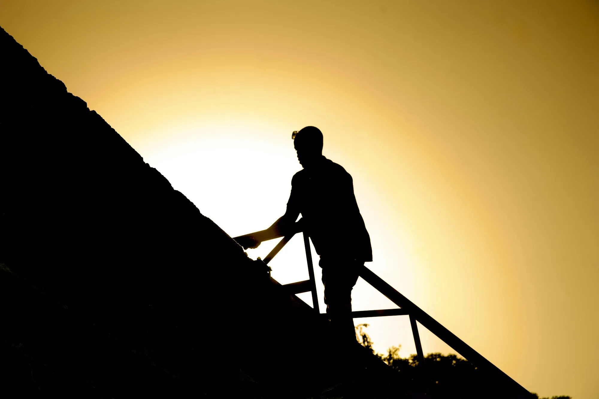 Roofer working on a roof against an evening sky