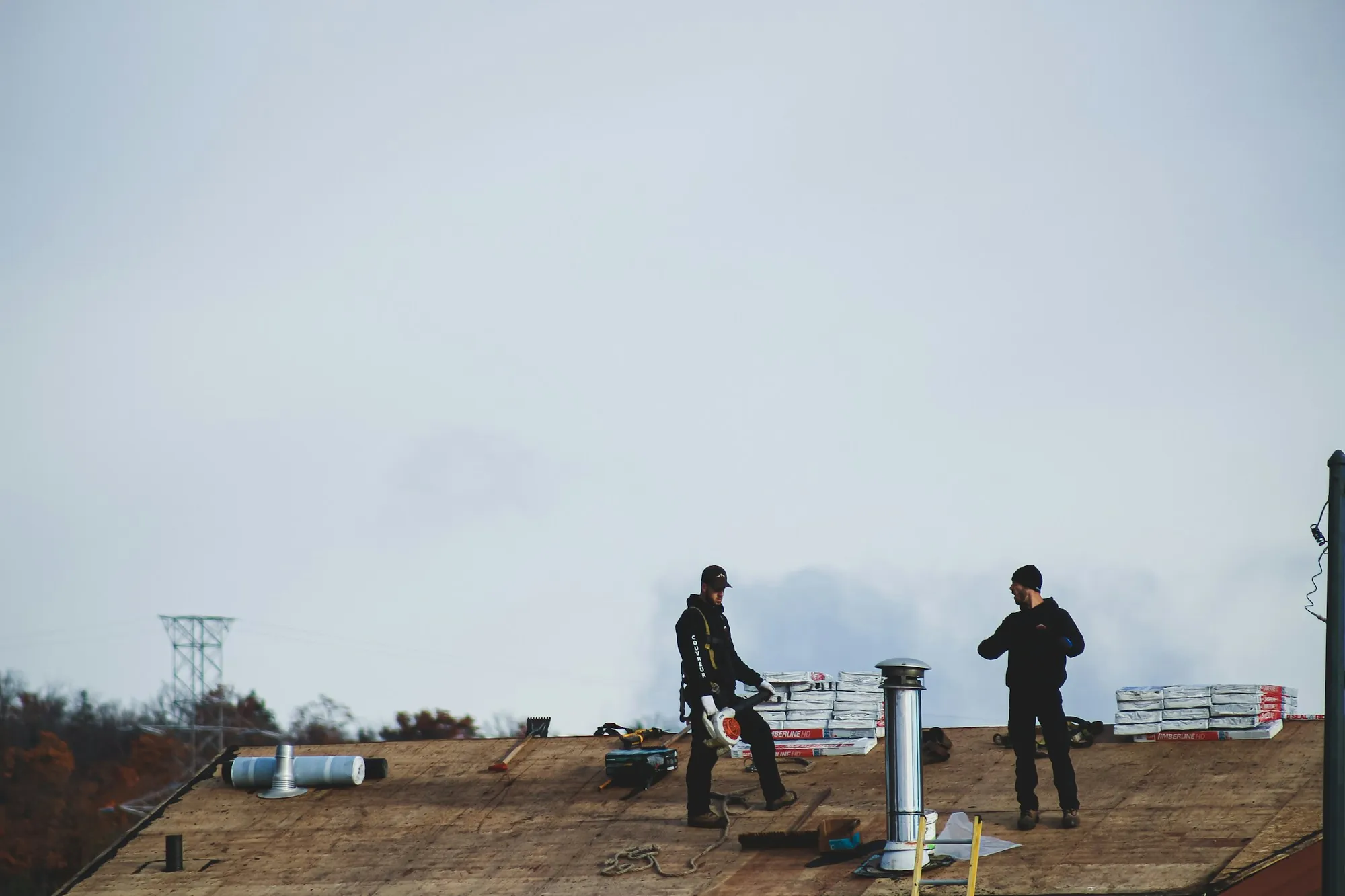 Two roofers standing on a house roof